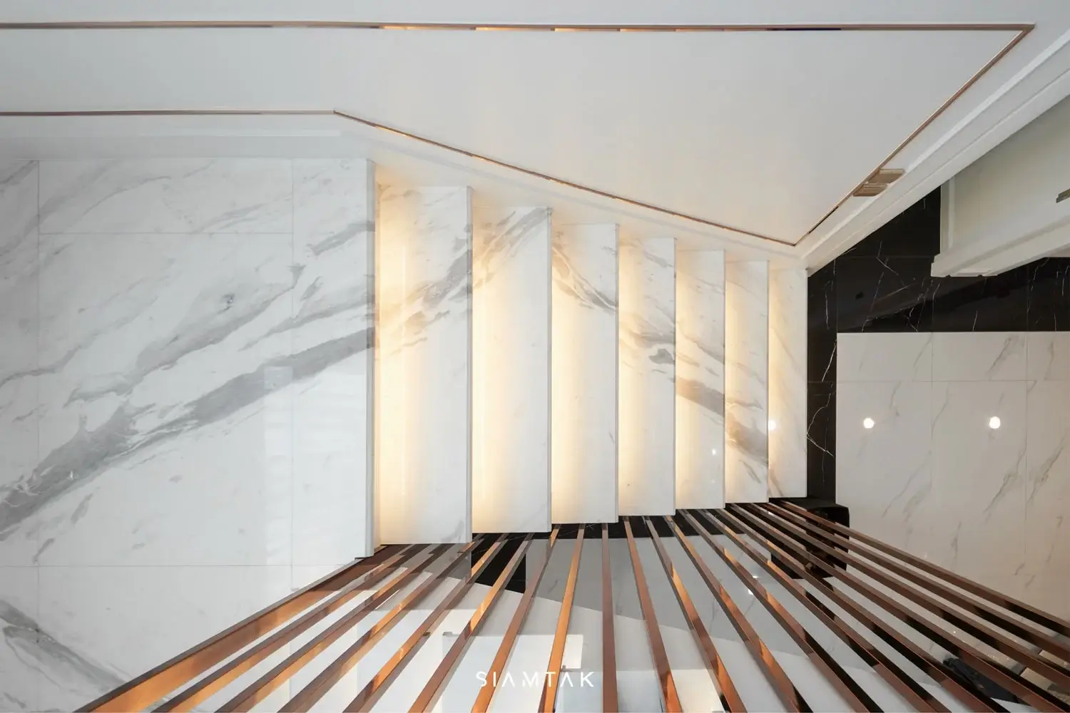 White Volakas marble staircase with a 180° angled cut and bookmatch pattern